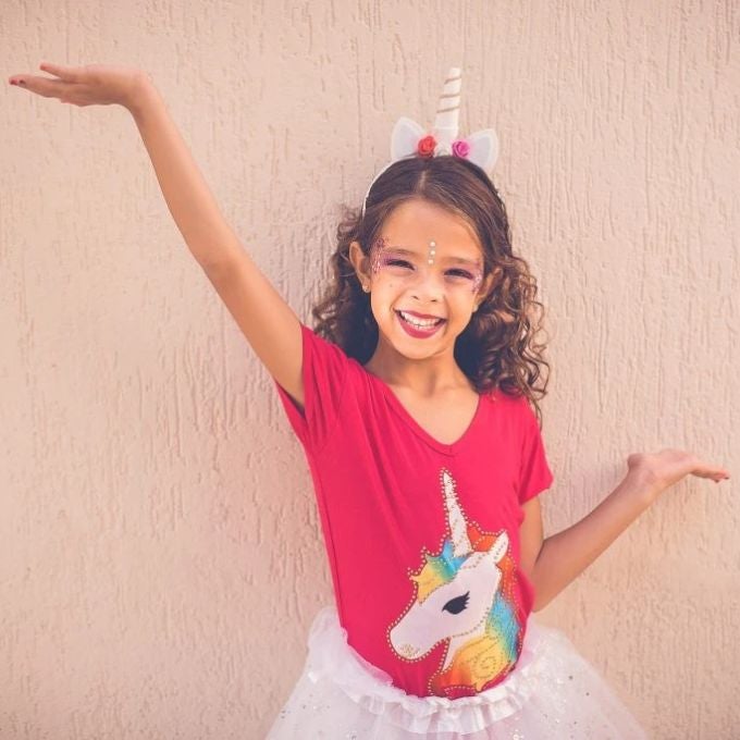 Petite fille en tee-shirt à licorne robe plus jupe blanche