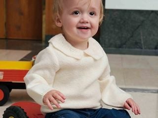 Petit garçon portant un pull à col blanc